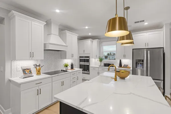 a kitchen with stainless steel appliances granite countertop a sink a stove and a refrigerator