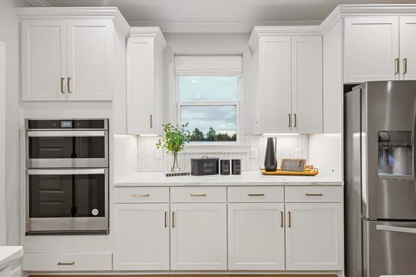 a kitchen with white cabinets and refrigerator