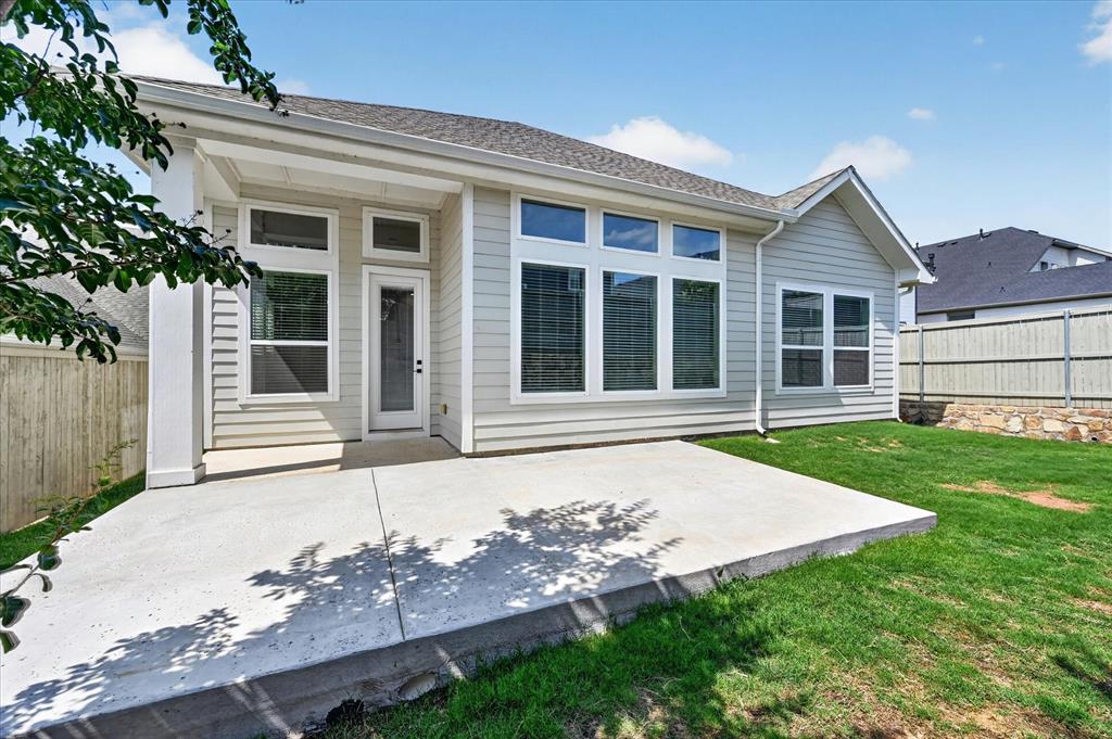 2237 Pika Road Northlake, TX 76247 - Photo 36 of 37 Rear exterior featuring a spacious concrete patio, light-colored horizontal siding, multiple large windows, a screened door, and a grass lawn