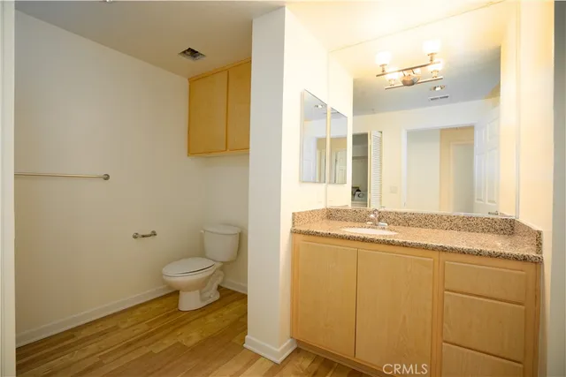 a bathroom with a granite countertop sink a toilet and a mirror