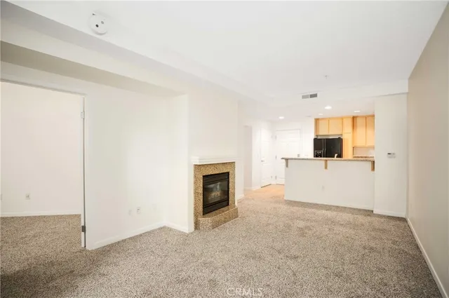 an empty room with a fireplace and wooden floor