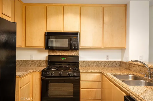 a kitchen with granite countertop cabinets stainless steel appliances and a sink