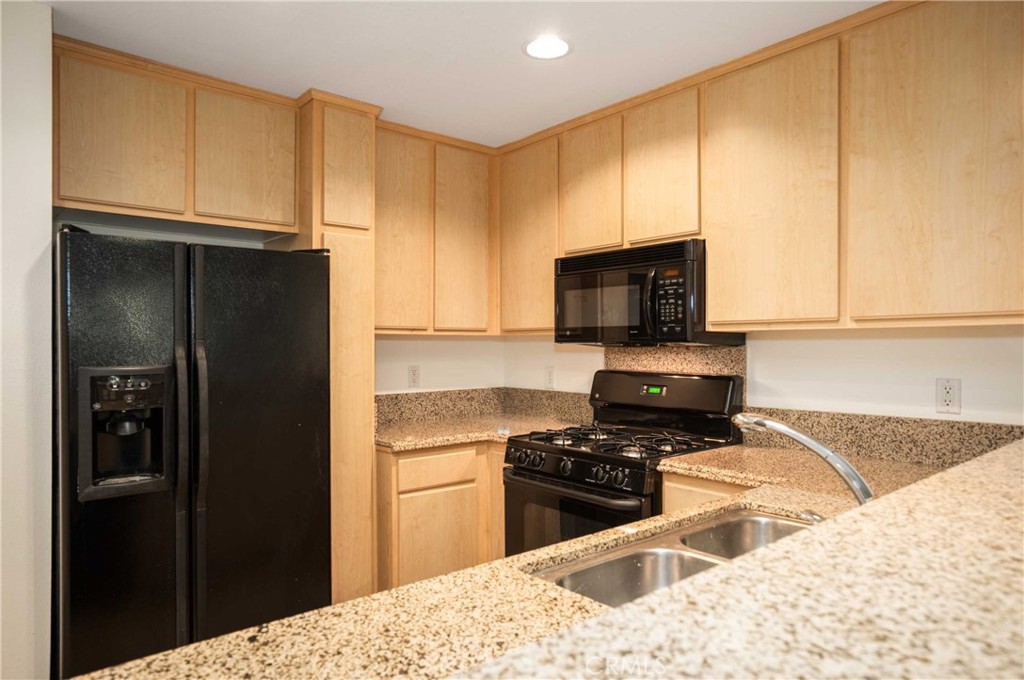 160 South Hudson Avenue, Unit 303 Pasadena, CA 91101 - Photo 6 of 14 a kitchen with a refrigerator stove and cabinets