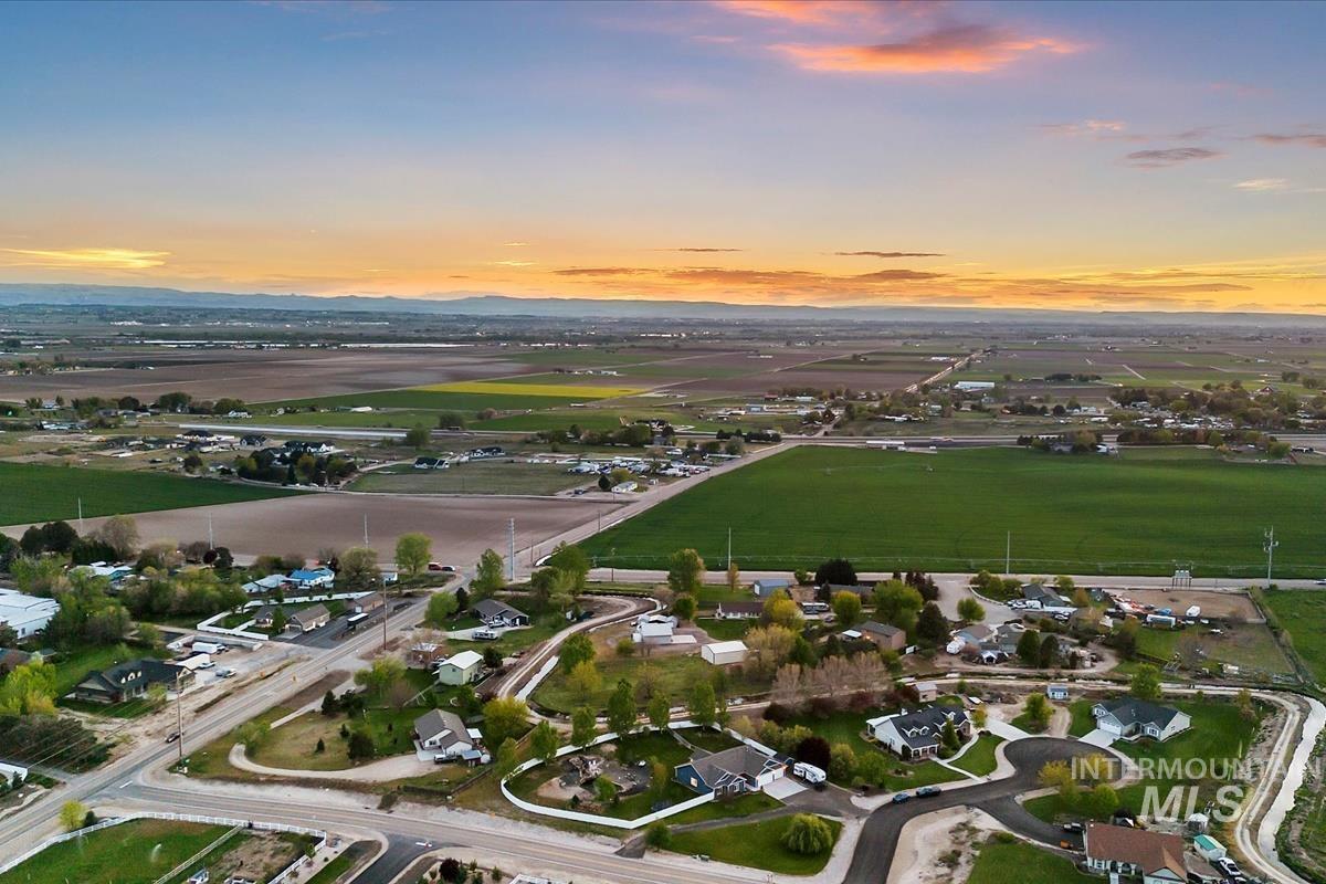 15015 Leon Lane Caldwell, ID 83607 - Photo 40 of 44 Aerial perspective showcasing a residential community surrounded by expansive agricultural fields and distant mountains