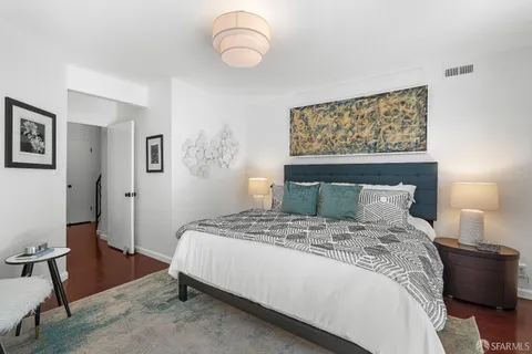 a bedroom with a large bed and a lamp