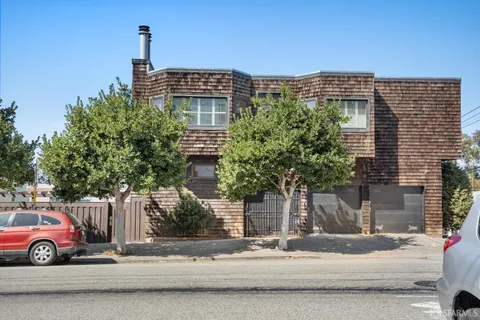 a balcony with chairs and a potted plant