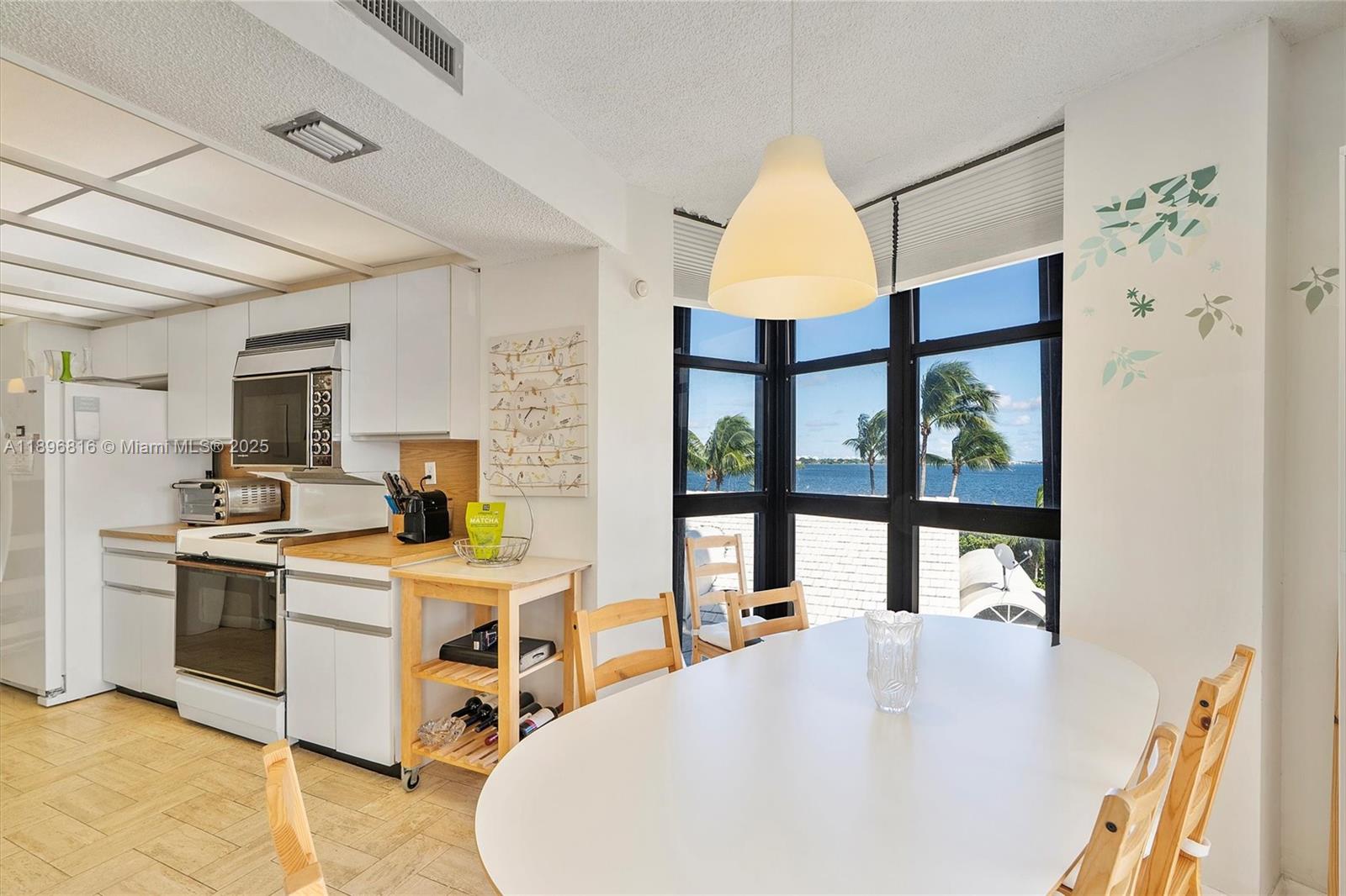 4000 Towerside Terrace, Unit 402 Miami, FL 33138 - Photo 11 of 54 a very nice looking open dining room with kitchen island furniture a large window and a kitchen view