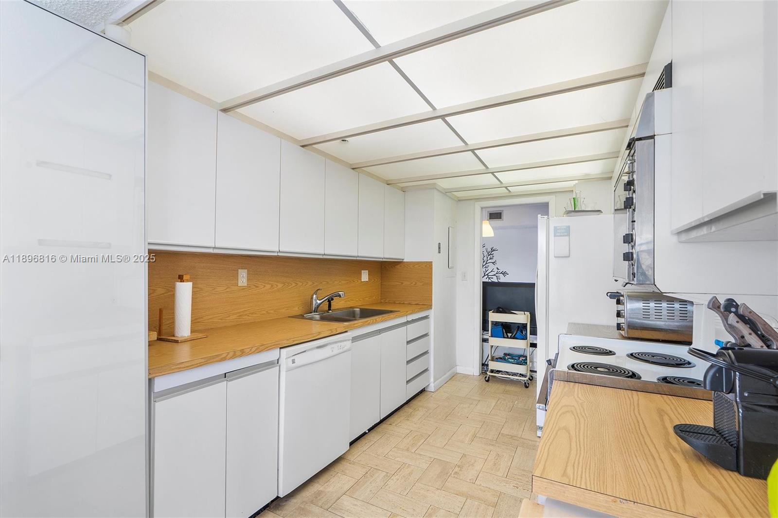 4000 Towerside Terrace, Unit 402 Miami, FL 33138 - Photo 13 of 54 a kitchen with cabinets and wooden floor
