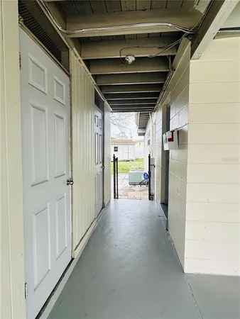 a view of hallway with a refrigerator and a wooden floor