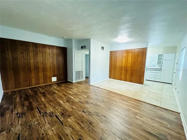 a view of an empty room with wooden floor