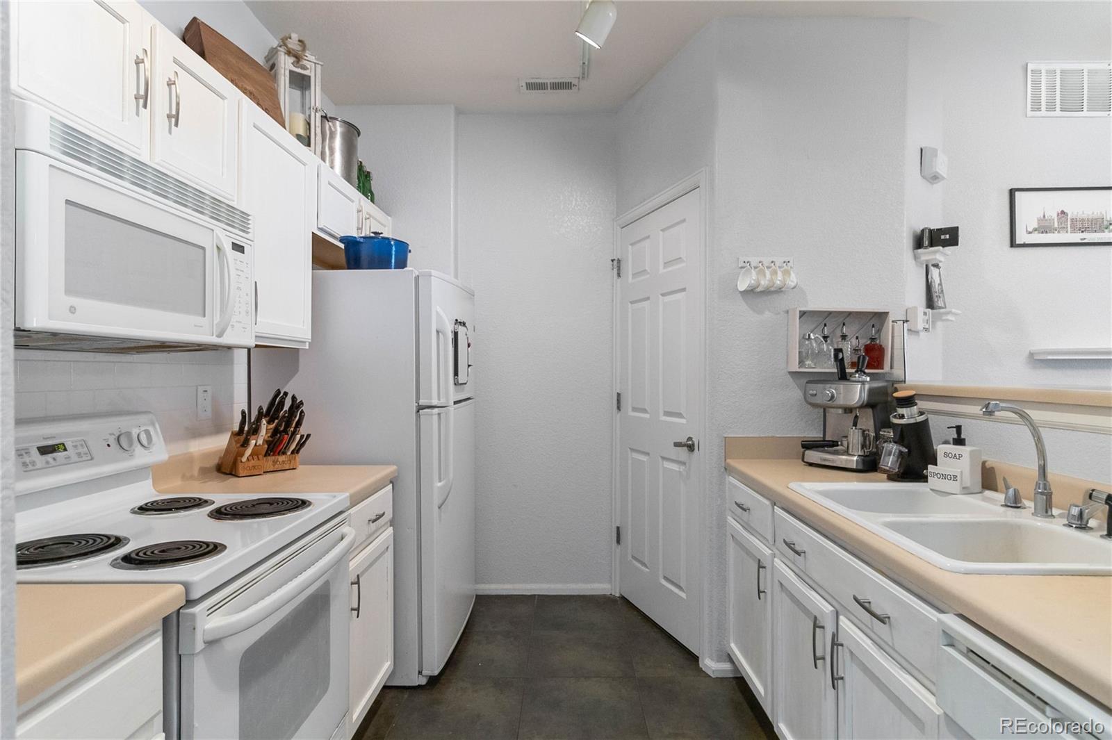 5255 Memphis Street, Unit 702 Denver, CO 80239 - Photo 7 of 30 a kitchen with a sink stove and refrigerator