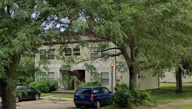 a front view of a building with trees