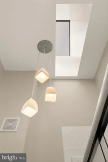 a bathroom with a light fixture a sink and a window