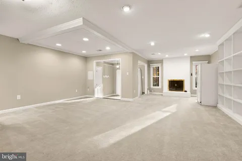 a view of an empty room with a fireplace and cabinet