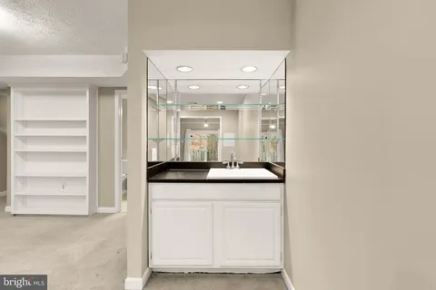 a bathroom with a granite countertop sink a toilet a mirror and bathtub