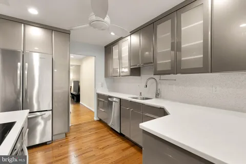 a large kitchen with a sink and stainless steel appliances