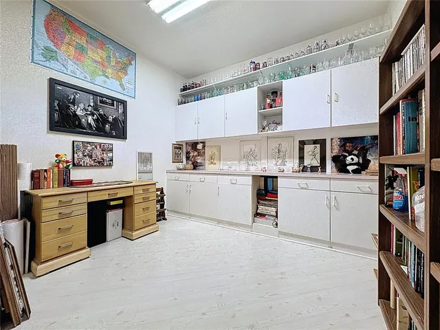 a view of a wooden house with large trees and wooden fence