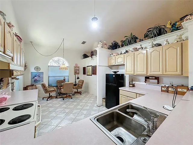 a kitchen with stainless steel appliances granite countertop a sink stove refrigerator and cabinets