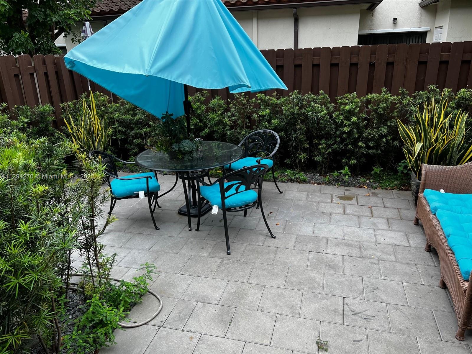 Oasis Homestead, FL 33033 - Photo 13 of 24 a view of garden with chairs and table under an umbrella