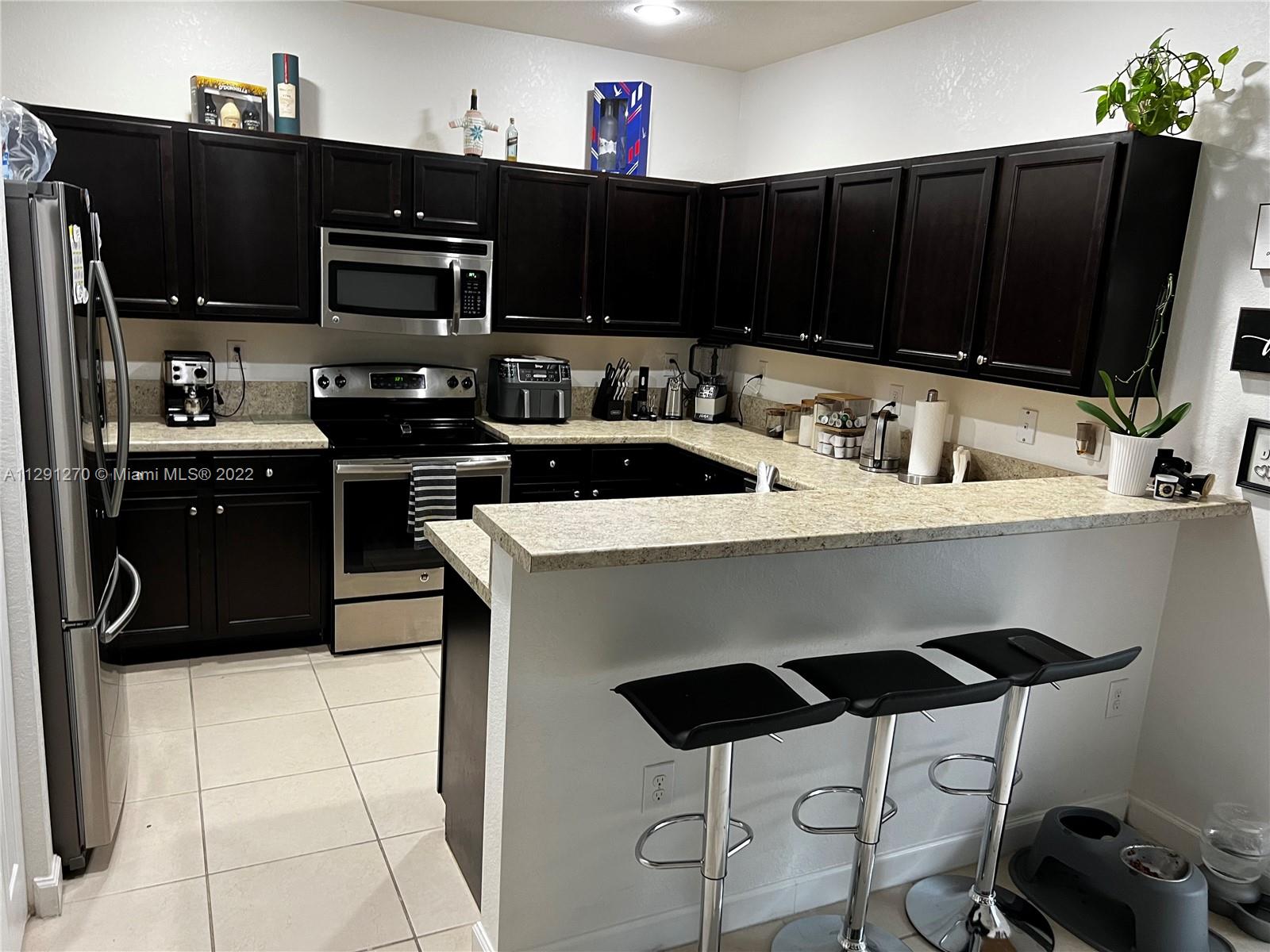 Oasis Homestead, FL 33033 - Photo 20 of 24 a kitchen with stainless steel appliances a stove a sink and a refrigerator