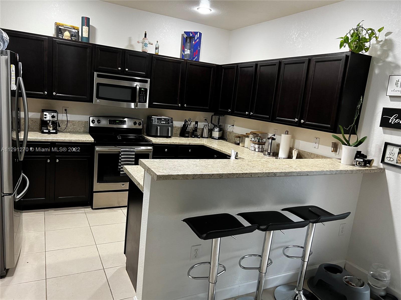 Oasis Homestead, FL 33033 - Photo 21 of 24 a kitchen with a sink a microwave and cabinets