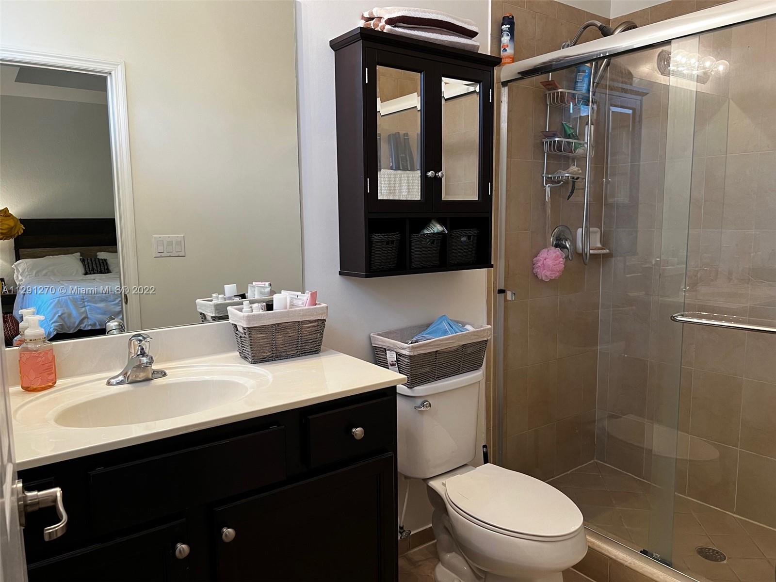 Oasis Homestead, FL 33033 - Photo 10 of 24 a bathroom with a sink a toilet a mirror and shower