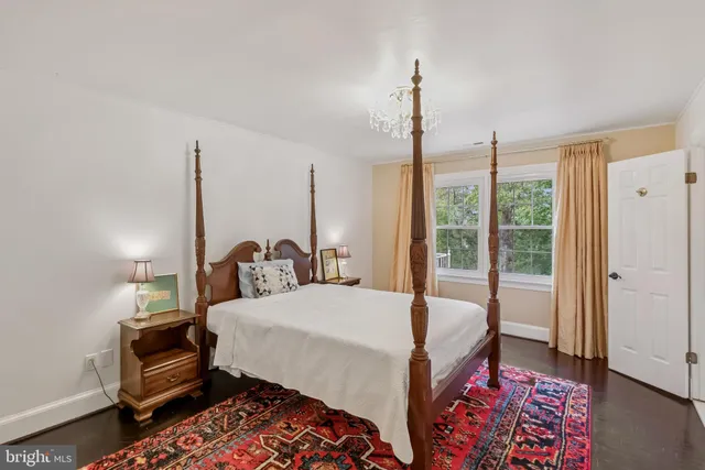 a spacious bedroom with a bed and a chandelier