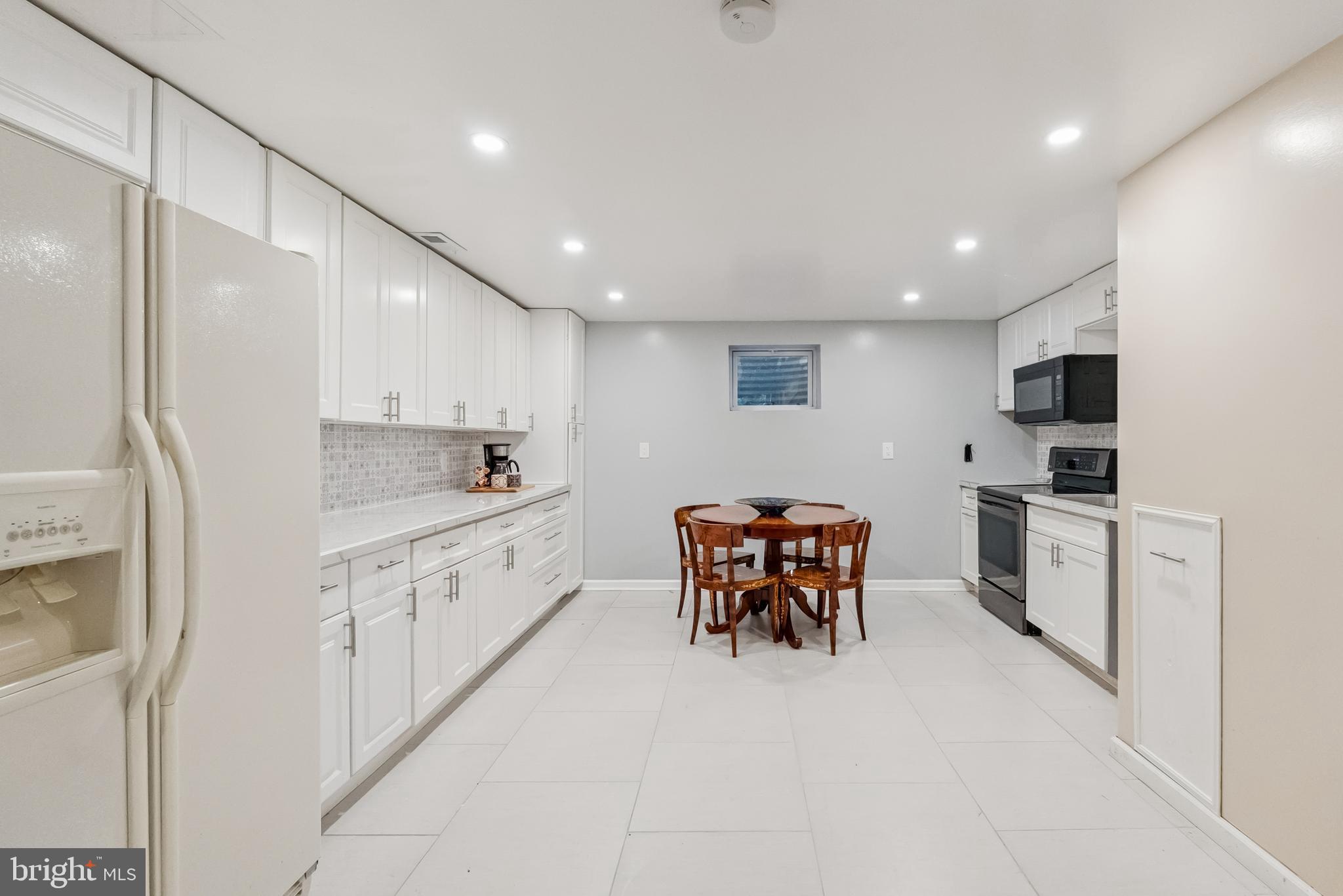 10900 Tara Road Potomac, MD 20854 - Photo 29 of 33 a large white kitchen with stainless steel appliances kitchen island granite countertop a sink and cabinets