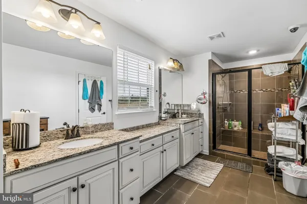 a large bathroom with a granite countertop sink mirror and shower