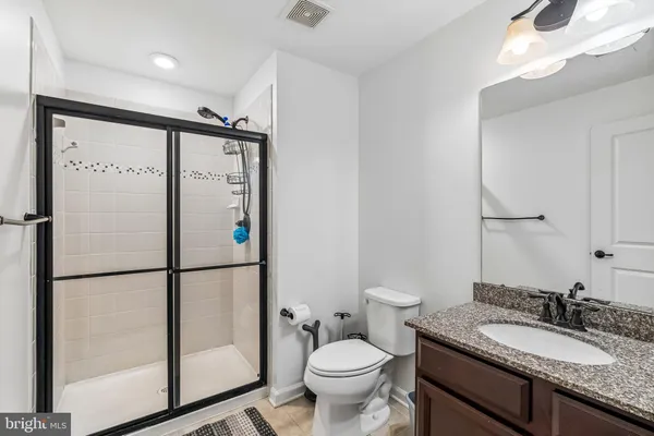 a bathroom with a granite countertop sink toilet and shower