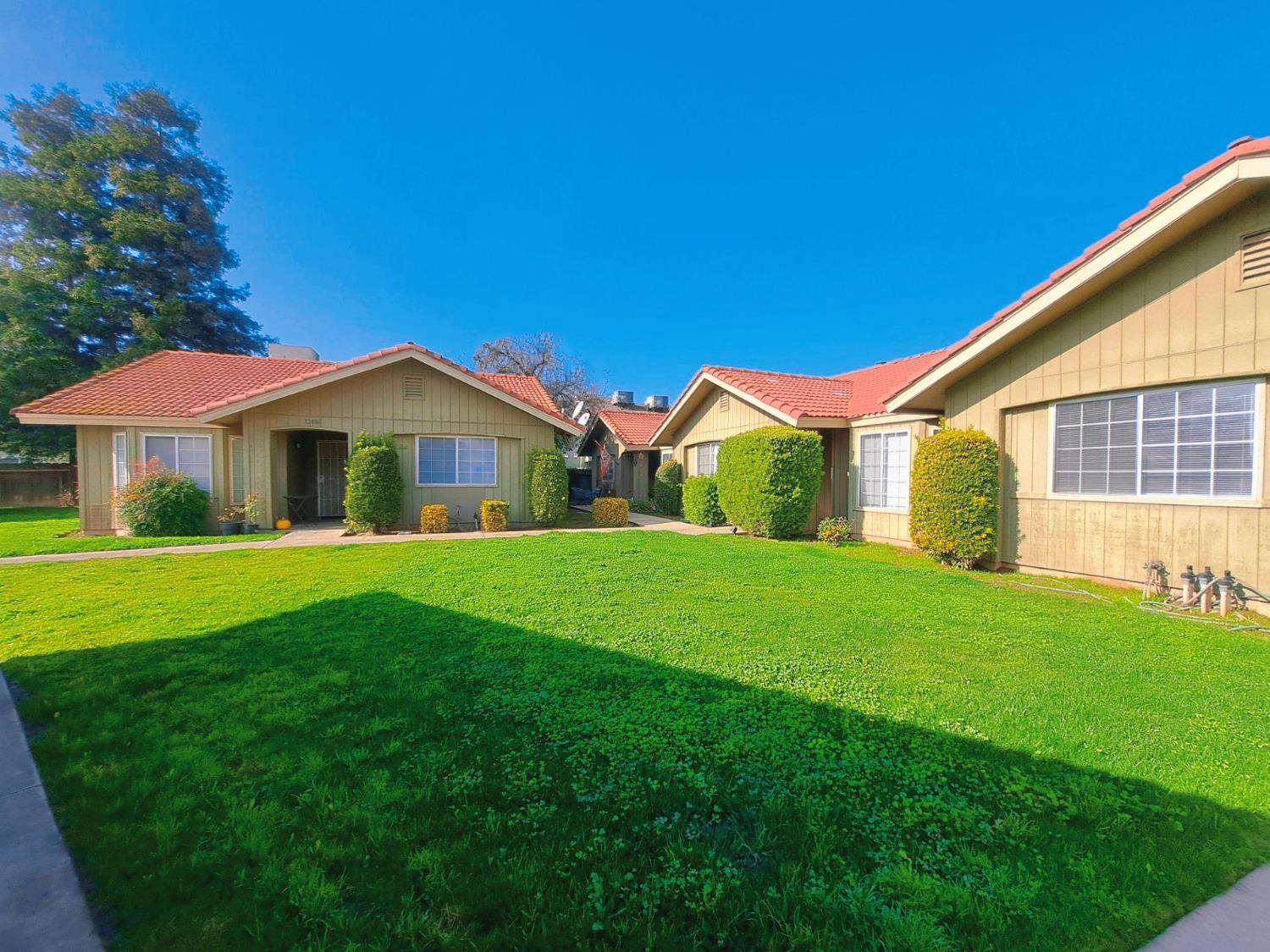 a view of an house with backyard and a tree