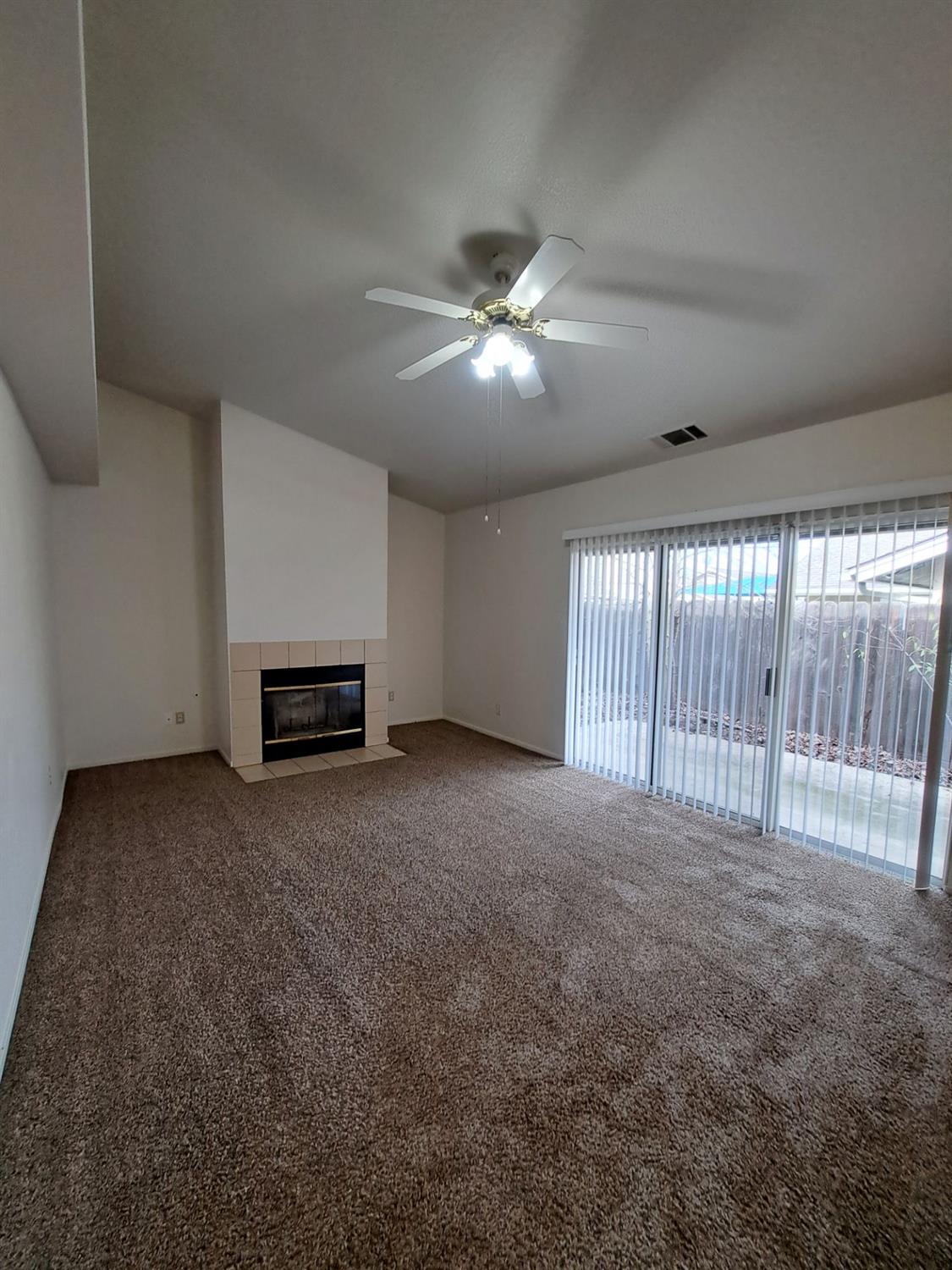 12486 Georgia Lane Madera, CA 93637 - Photo 5 of 17 a view of a livingroom with furniture chandelier fan and a fireplace