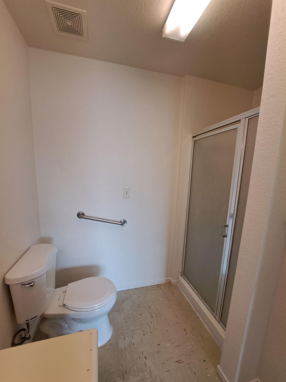 12486 Georgia Lane Madera, CA 93637 - Photo 9 of 17 a white toilet sitting next to a shower
