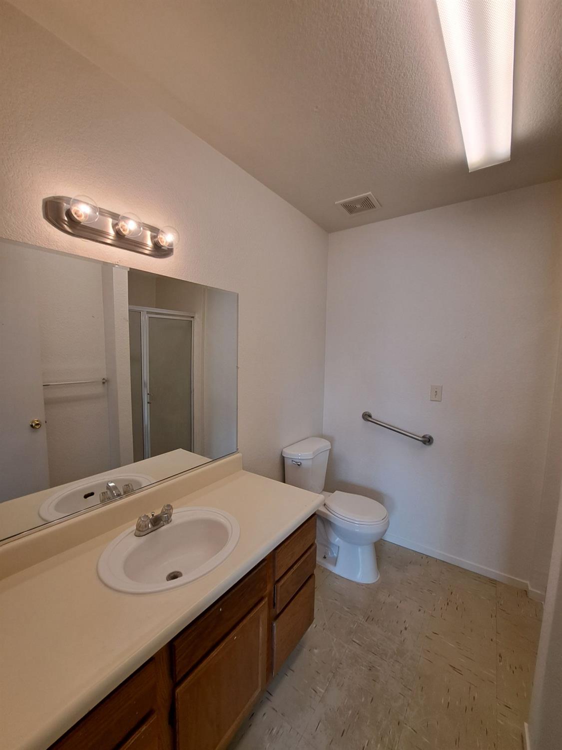 12486 Georgia Lane Madera, CA 93637 - Photo 10 of 17 a bathroom with a sink a toilet and mirror