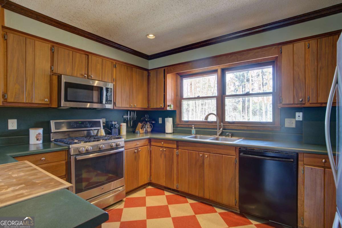 1043 Wilkerson Road Southwest Rome, GA 30165 - Photo 27 of 52 a kitchen with granite countertop a sink stove top oven and microwave
