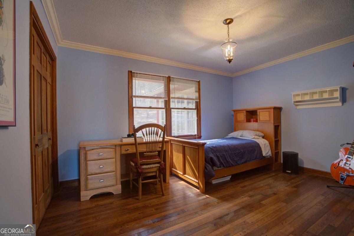 1043 Wilkerson Road Southwest Rome, GA 30165 - Photo 36 of 52 a spacious bedroom with a bed and a chandelier