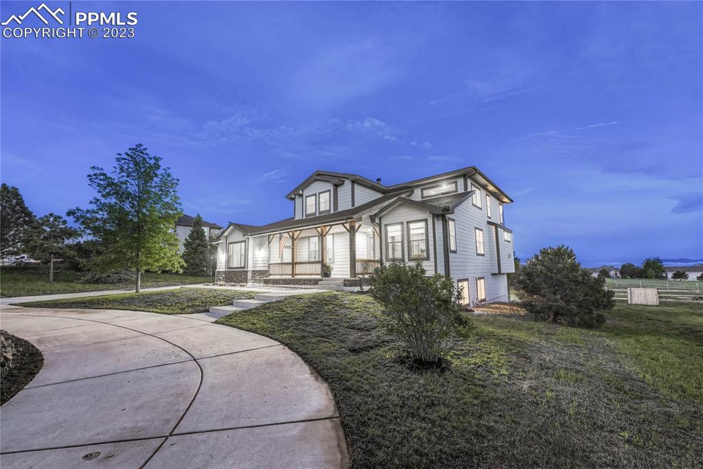 1185 Bowstring Road Monument, CO 80132 - Photo 1 of 46 a front view of a house with a yard and trees