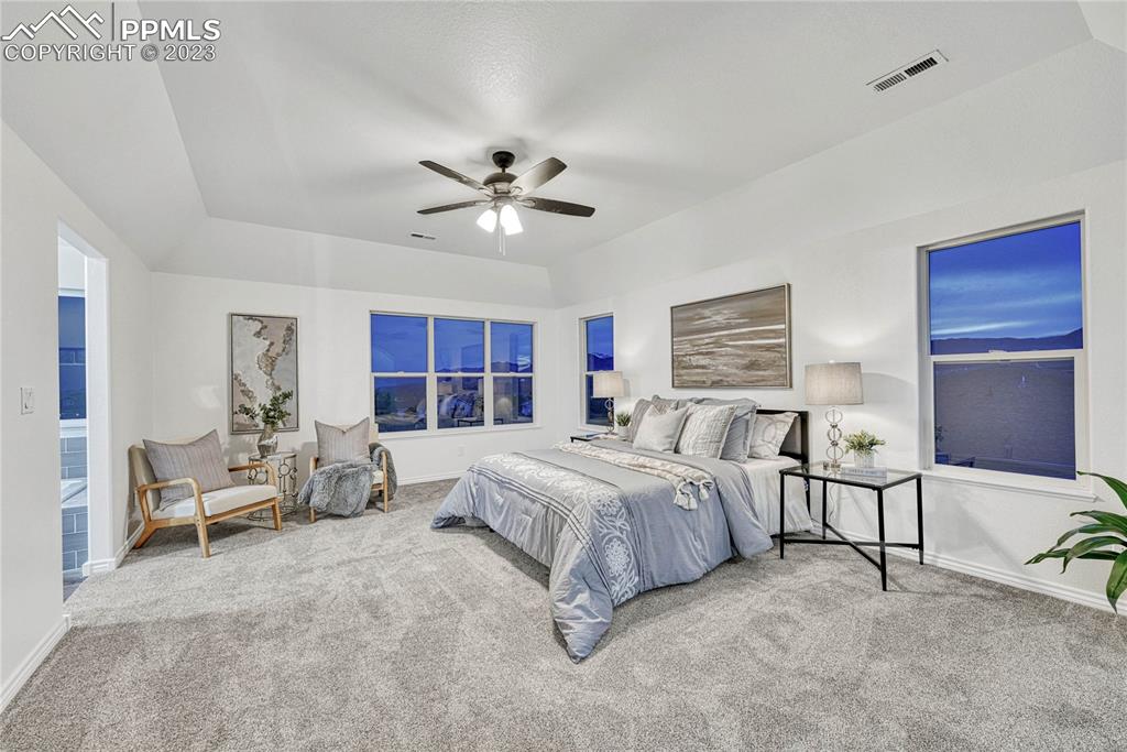1185 Bowstring Road Monument, CO 80132 - Photo 21 of 46 a spacious bedroom with a bed a table and chair