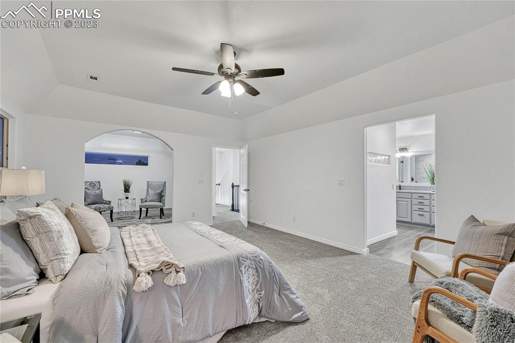 1185 Bowstring Road Monument, CO 80132 - Photo 24 of 46 a spacious bedroom with a bed and furniture