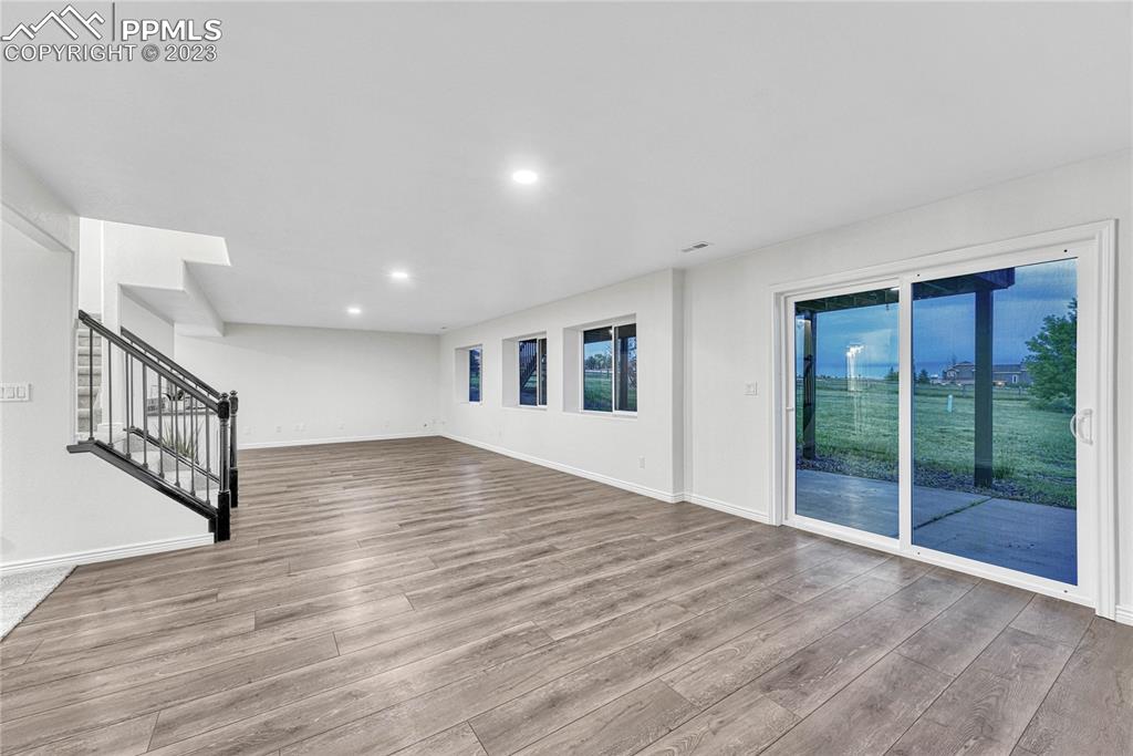 1185 Bowstring Road Monument, CO 80132 - Photo 31 of 46 a view of an empty room with wooden floor and a window