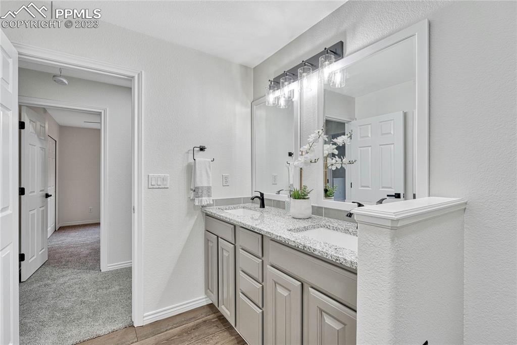 1185 Bowstring Road Monument, CO 80132 - Photo 38 of 46 a bathroom with a granite countertop sink and a mirror