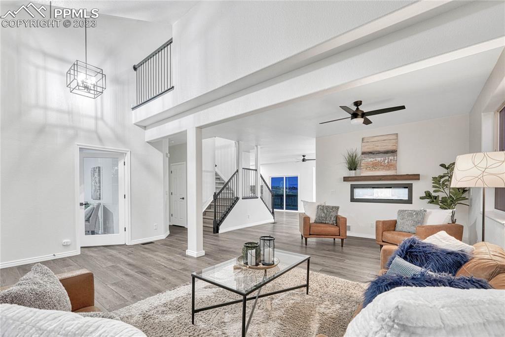 1185 Bowstring Road Monument, CO 80132 - Photo 5 of 46 a living room with furniture a table and a chandelier