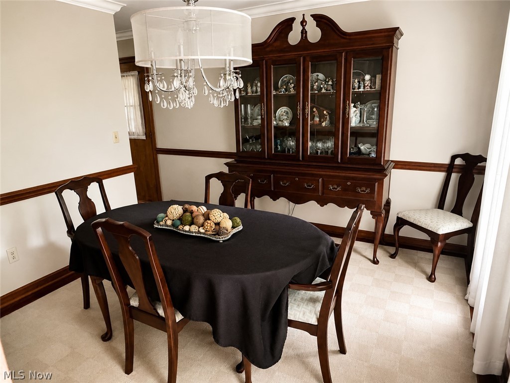 6155 Gibson Road Canfield, OH 44406 - Photo 13 of 43 Dining area featuring a crystal chandelier, crown molding, and wood-trim accents