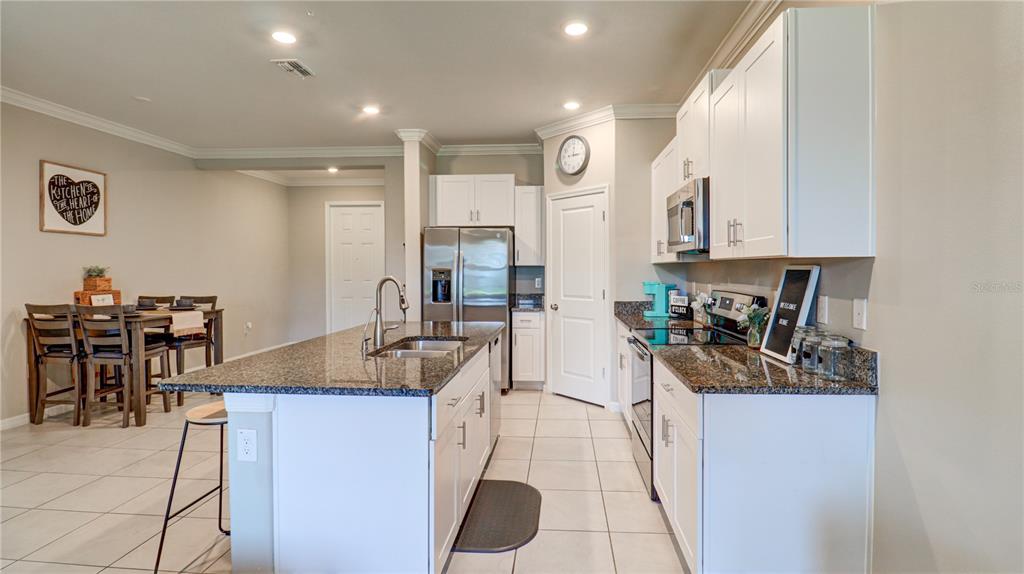 31632 Blue Passing Loop Wesley Chapel, FL 33545 - Photo 15 of 48 a kitchen with stainless steel appliances kitchen island granite countertop a sink and cabinets