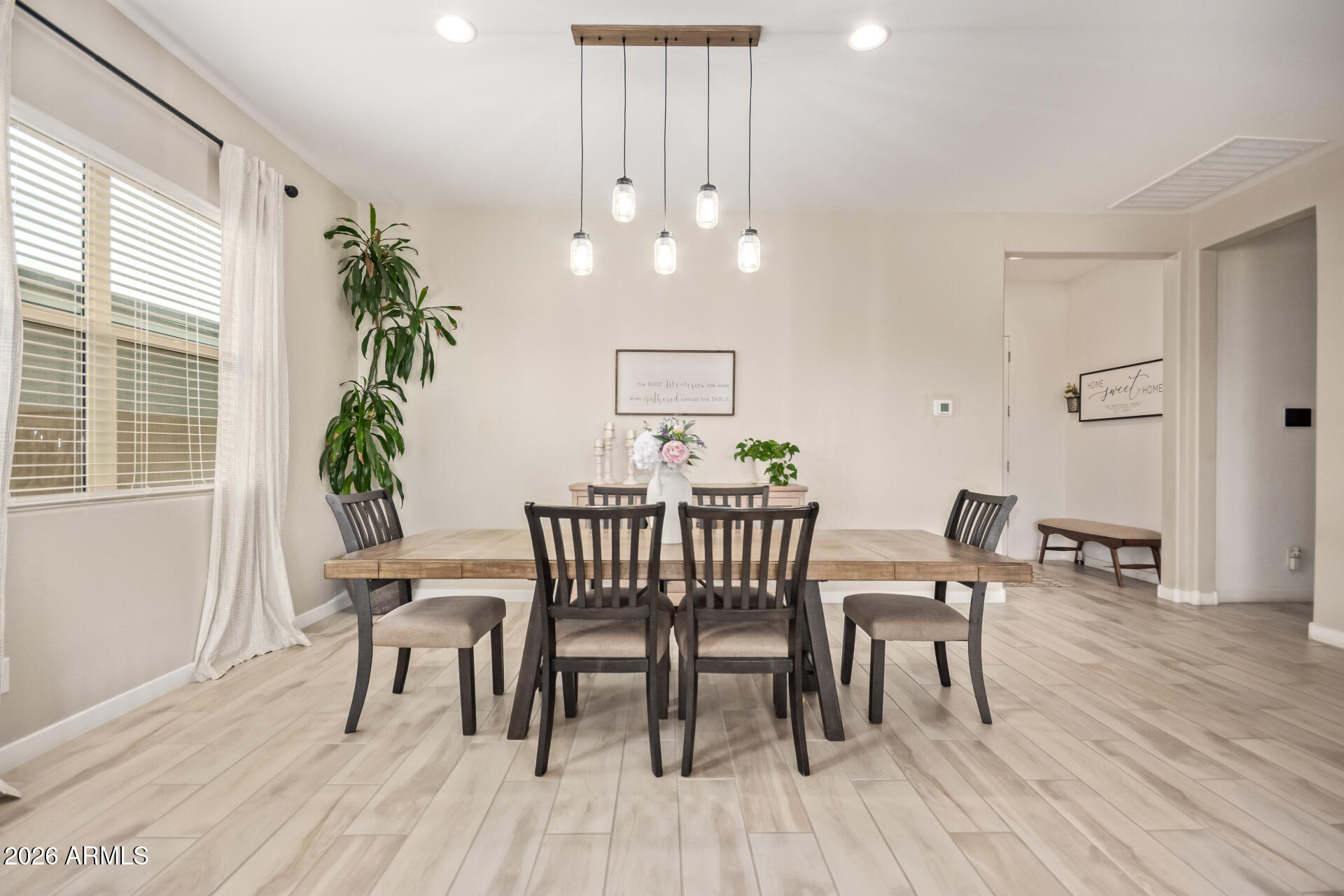 3918 West McNeil Street Laveen, AZ 85339 - Photo 14 of 42 a dining room with furniture potted plants and wooden floor