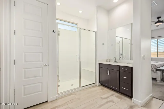 a bathroom with a mirror a double vanity sink and glass door