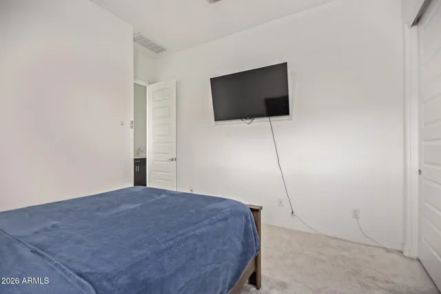 a bedroom with a bed and a flat screen tv