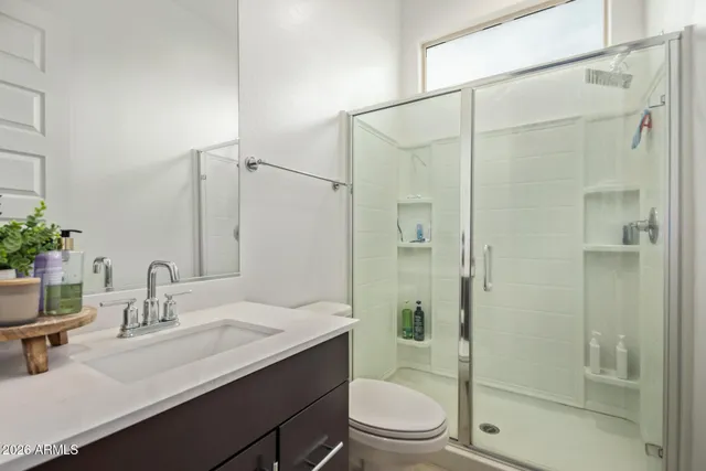 a bathroom with a sink toilet double vanity and shower