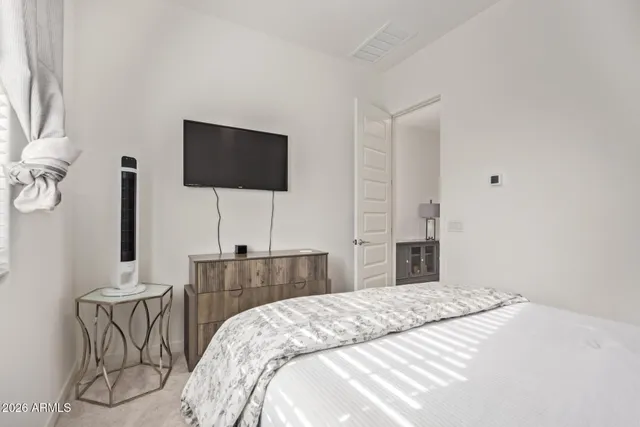 a bedroom with a bed and a flat screen tv