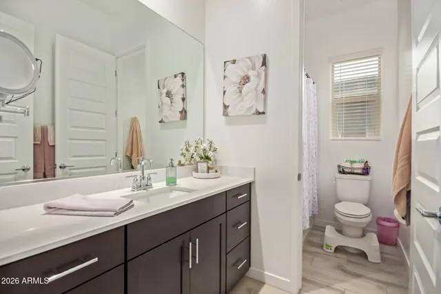 a bathroom with a granite countertop toilet sink and mirror